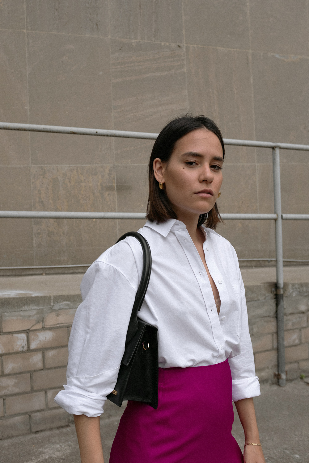 Nisi is wearing: White shirt – & Other Stories, Fuchsia skirt – Massimo Dutti, Le Grand Chiquito bag – Jacquemus, Strappy sandals – Mango, Dinner Date earrings – All Blues