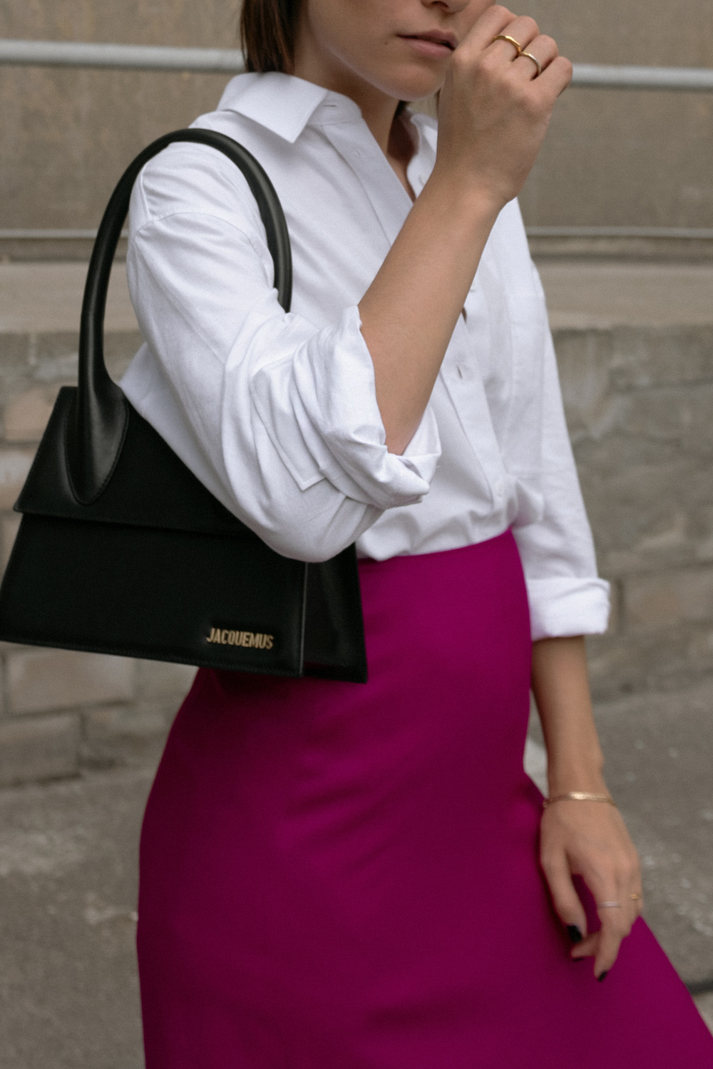 Nisi is wearing: White shirt – & Other Stories, Fuchsia skirt – Massimo Dutti, Le Grand Chiquito bag – Jacquemus, Strappy sandals – Mango, Dinner Date earrings – All Blues