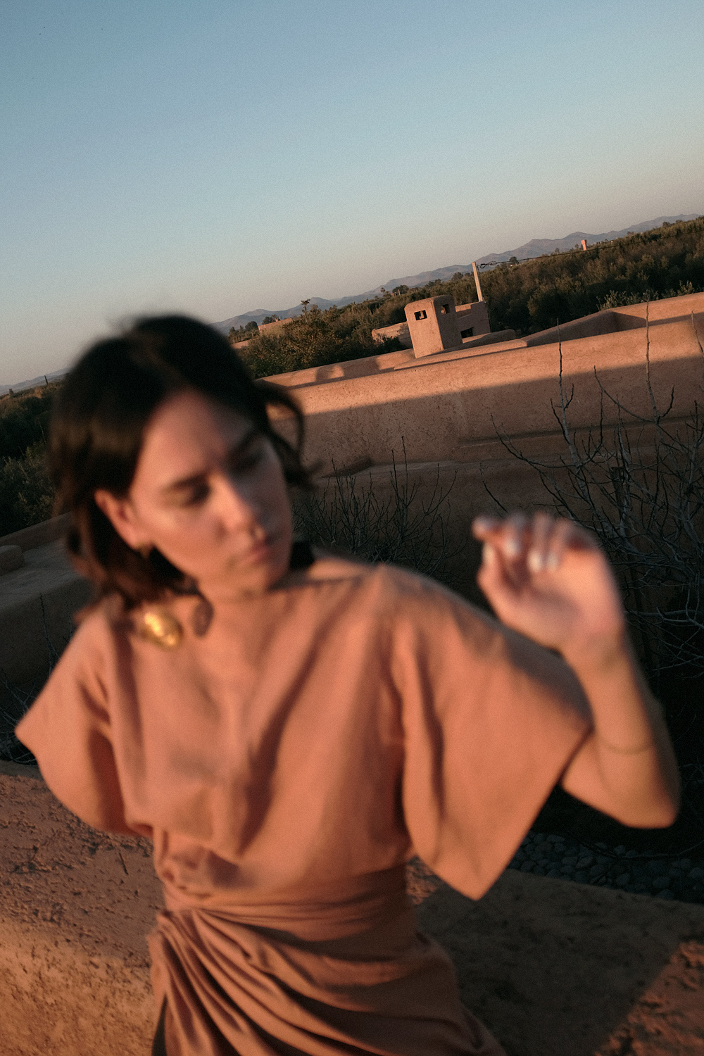 Nisi is wearing: Jacquemus La Robe Salvador dress and Le Carre earrings, The Row Chocolate Sandals in Morocco