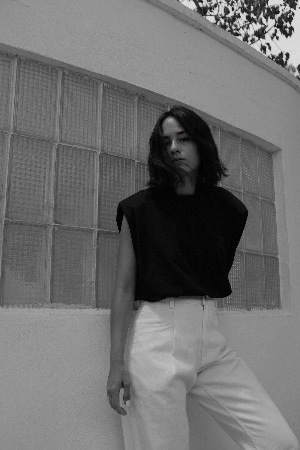 Nisi is wearing: Padded muscle shirt EDITED THE LABEL, White denim jeans EDITED THE LABEL, Flip flop heels TOTÊME, Fat Snake ring in silver ALL BLUES, Fat gold ring DAPHINE