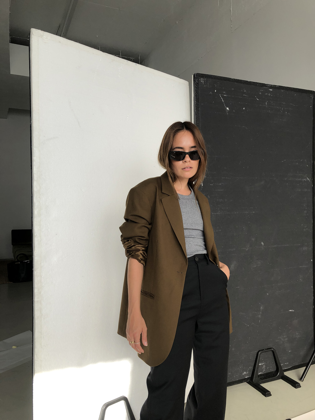 Desi is wearing: Oversized wool hopsack blazer – Arket, Ribbed racerback top – Totême, Light wool pants – Uniqlo x J.W.Anderson, Supercourt sneakers – Adidas Originals, Script-Logo sunglasses – Saint Laurent