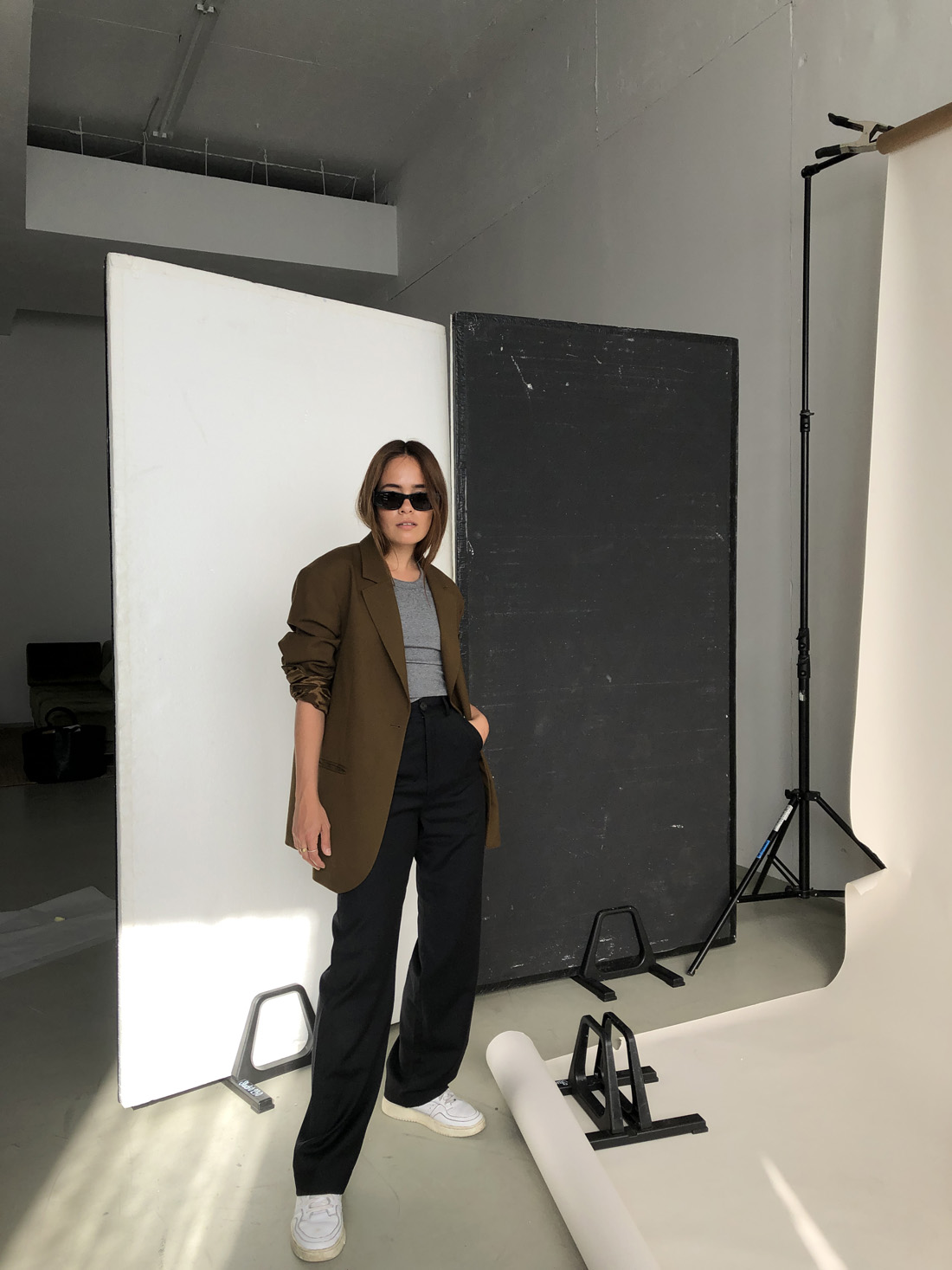 Desi is wearing: Oversized wool hopsack blazer – Arket, Ribbed racerback top – Totême, Light wool pants – Uniqlo x J.W.Anderson, Supercourt sneakers – Adidas Originals, Script-Logo sunglasses – Saint Laurent