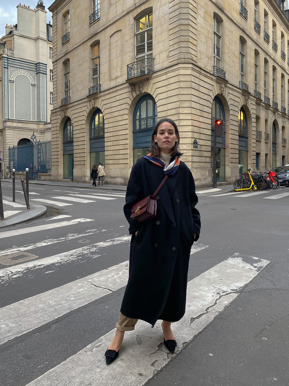 Spring Outfit. Nisi is wearing: Black wool coat ACNE STUDIOS, Beige denim jeans ZARA, Classic Box bag in bordeaux CÉLINE, Maysale mules MANOLO BLAHNIK, Vintage silk scarf HERMÈS