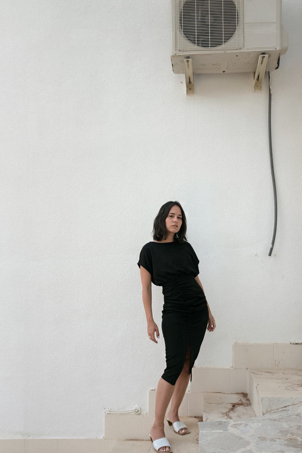 Nisi is wearing: Bottega Veneta Clogs Sandals, black tube dress