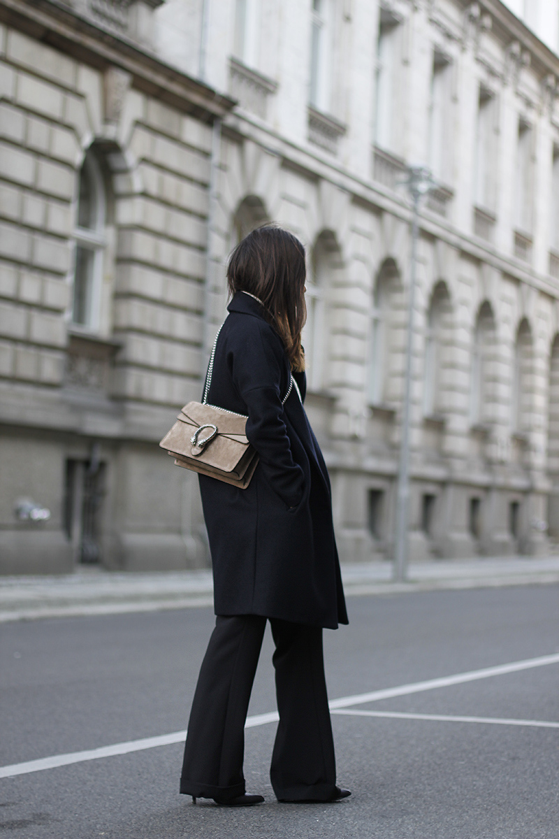 Nisi is wearing: Gucci Dionysus Bag, flared trousers from Warehouse, oversized coat from All Saints and high neck sweater from Gina Tricot