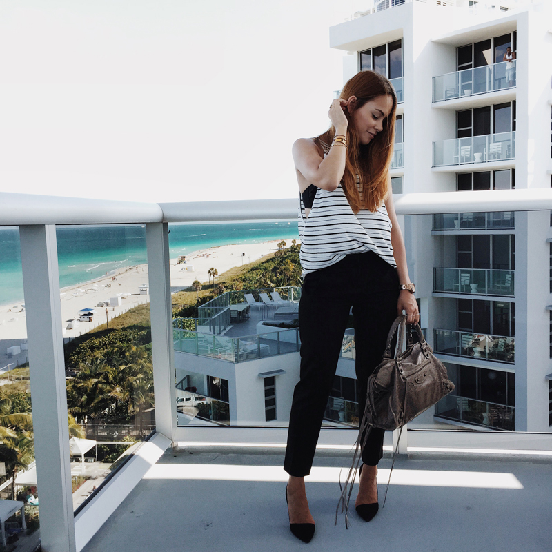 Desi is wearing a striped top from Bassike, cigarette pants, pointed cut-out pumps and a beige Balenciaga City Classig Bag for the Urban Decay Summer Nights in Miami