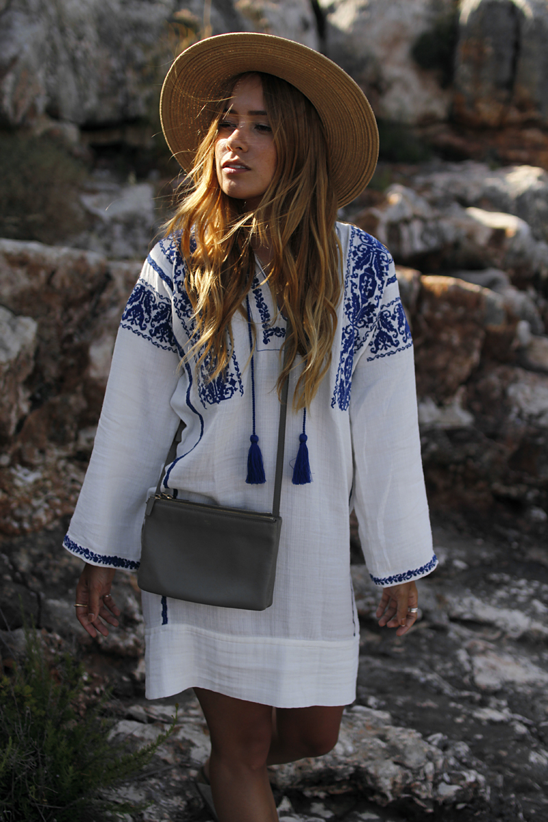 Outfit: Embroided Tunic in Cala Figuera. Desi is wearing a Céline trio bag, Arizona Brikenstock sandals, straw hat and Isabel Marant embroided tunic