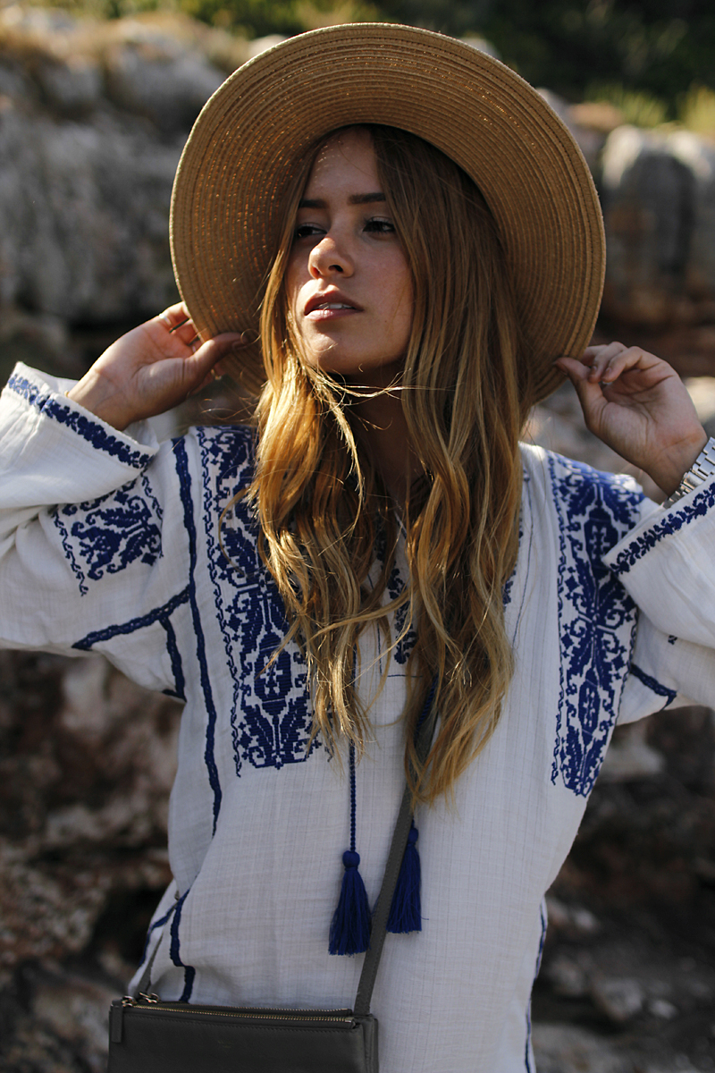 Outfit: Embroided Tunic in Cala Figuera. Desi is wearing a Céline trio bag, Arizona Brikenstock sandals, straw hat and Isabel Marant embroided tunic