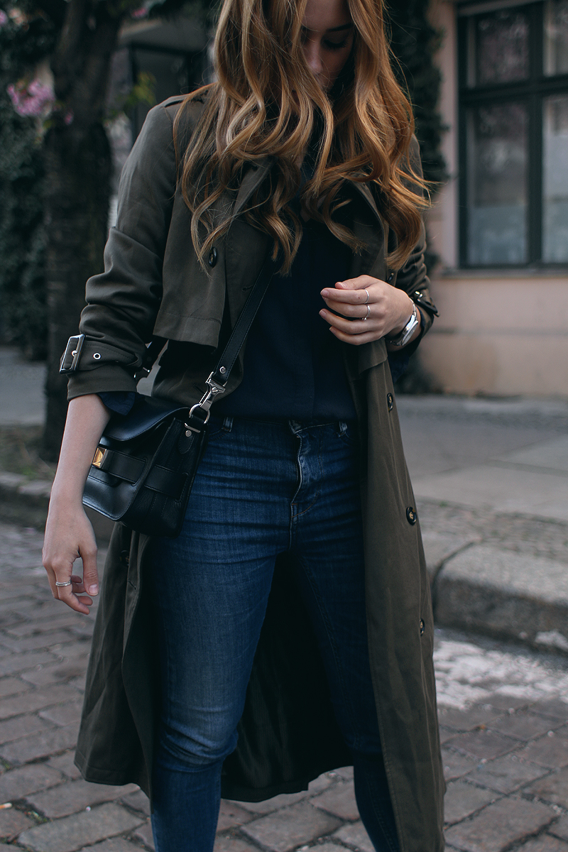 Desi is wearing: Oversized trench coat, Proenza Schouler PS11 Mini Classi bag, Isabel Marant Raelyn suede boots, navy skinny jeans, navy blouse, boyfriend watch