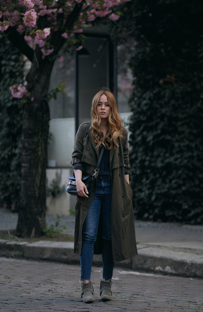 Desi is wearing: Oversized trench coat, Proenza Schouler PS11 Mini Classi bag, Isabel Marant Raelyn suede boots, navy skinny jeans, navy blouse, boyfriend watch