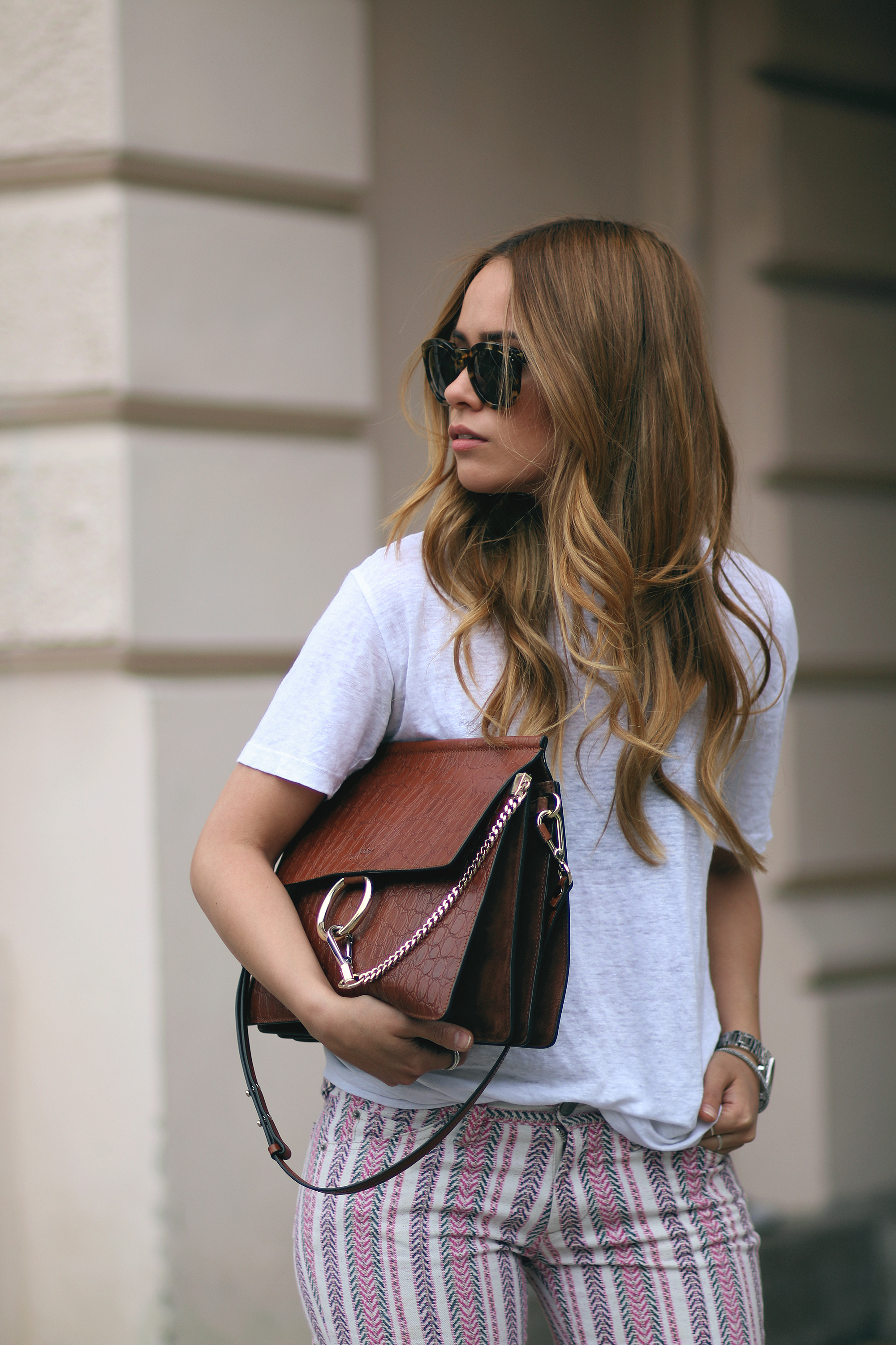 Desi wearing: Isabel Marant Étoile Printed trousers, Hermès Oran sandals, Chloé Faye bag, Céline Sunglasses, white linen shirt, boyfriend watch