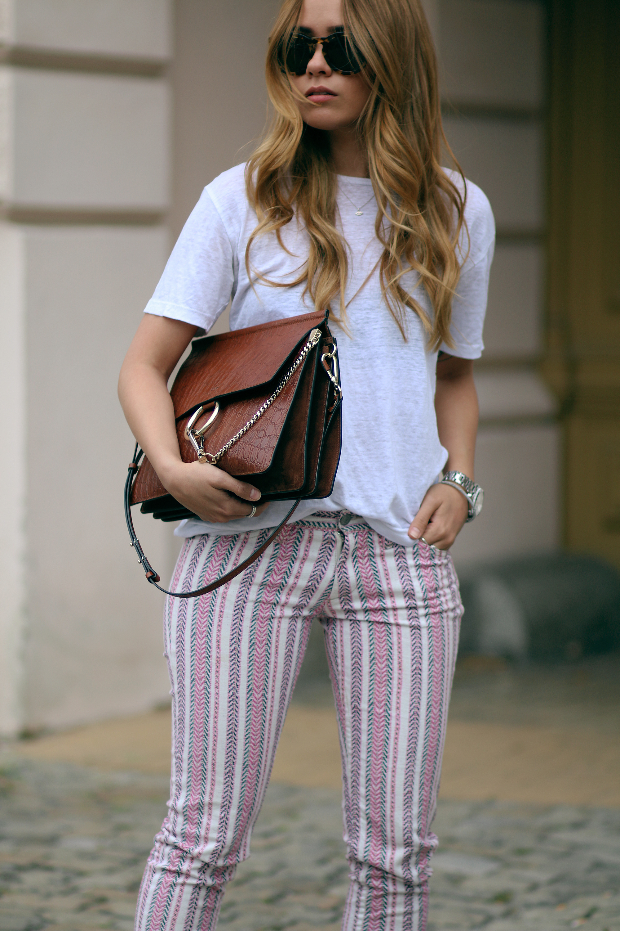 Desi wearing: Isabel Marant Étoile Printed trousers, Hermès Oran sandals, Chloé Faye bag, Céline Sunglasses, white linen shirt, boyfriend watch