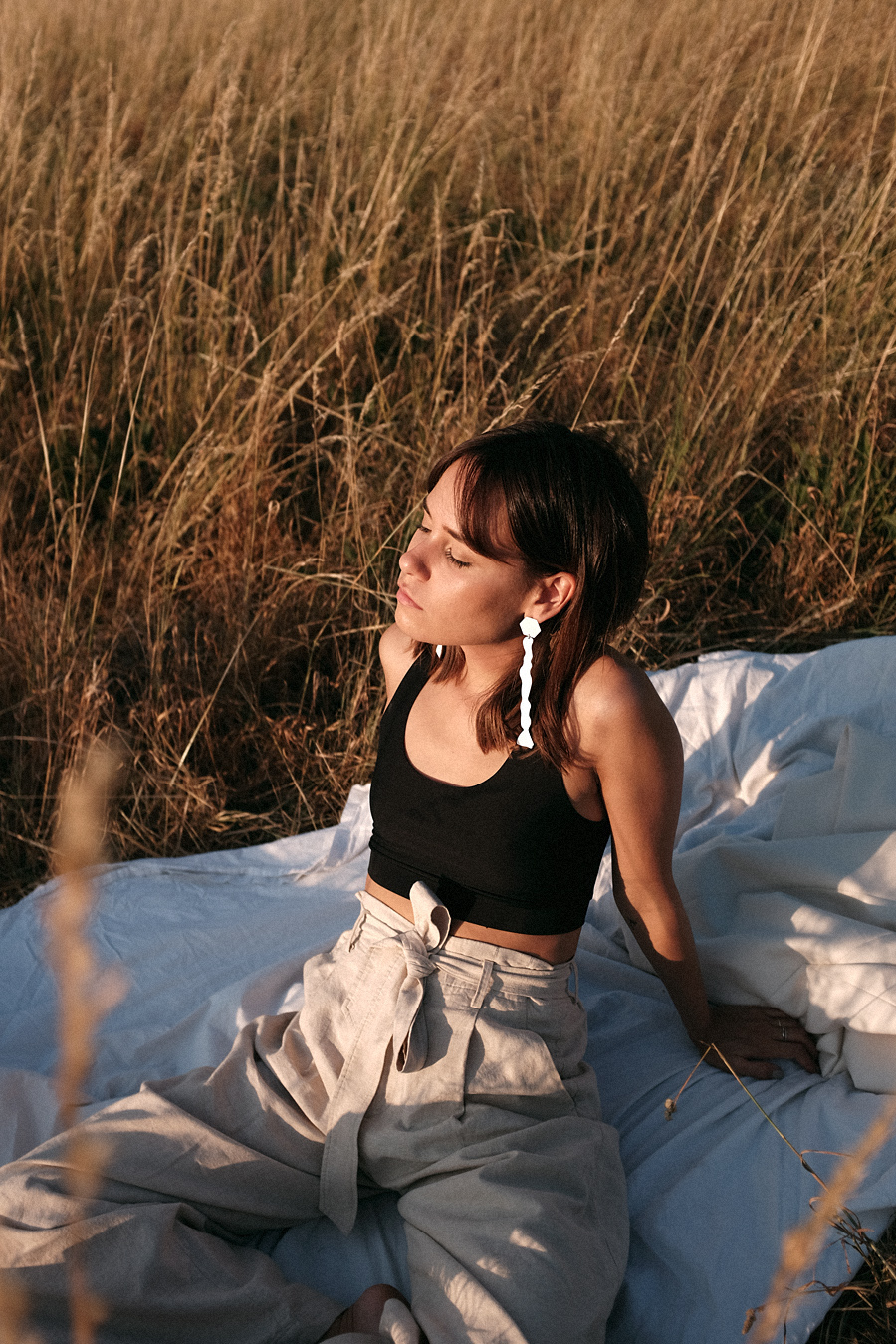 Nisi is wearing: Uniqlo linen paperbag trousers, Arket White blazer, Chanelle black bralette, Mango white statement earrings