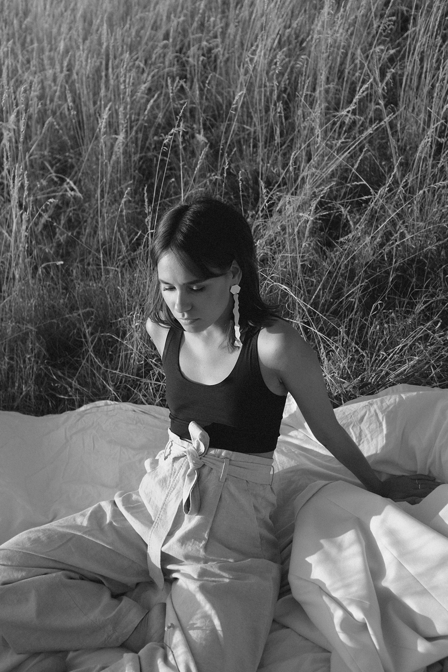 Nisi is wearing: Uniqlo linen paperbag trousers, Arket White blazer, Chanelle black bralette, Mango white statement earrings