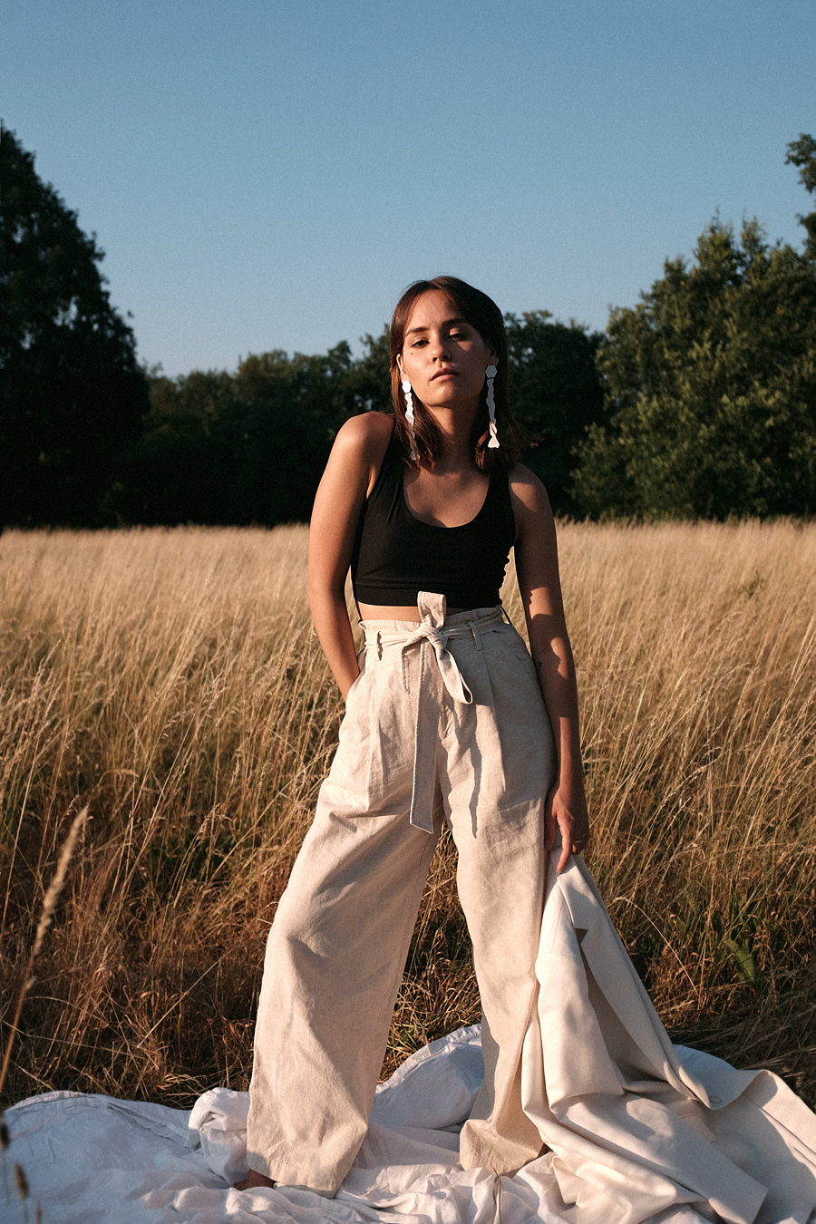 Nisi is wearing: Uniqlo linen paperbag trousers, Arket White blazer, Chanelle black bralette, Mango white statement earrings
