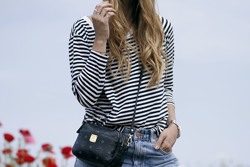 Desi is wearing a striped shirt, denim shorts and MCM bag