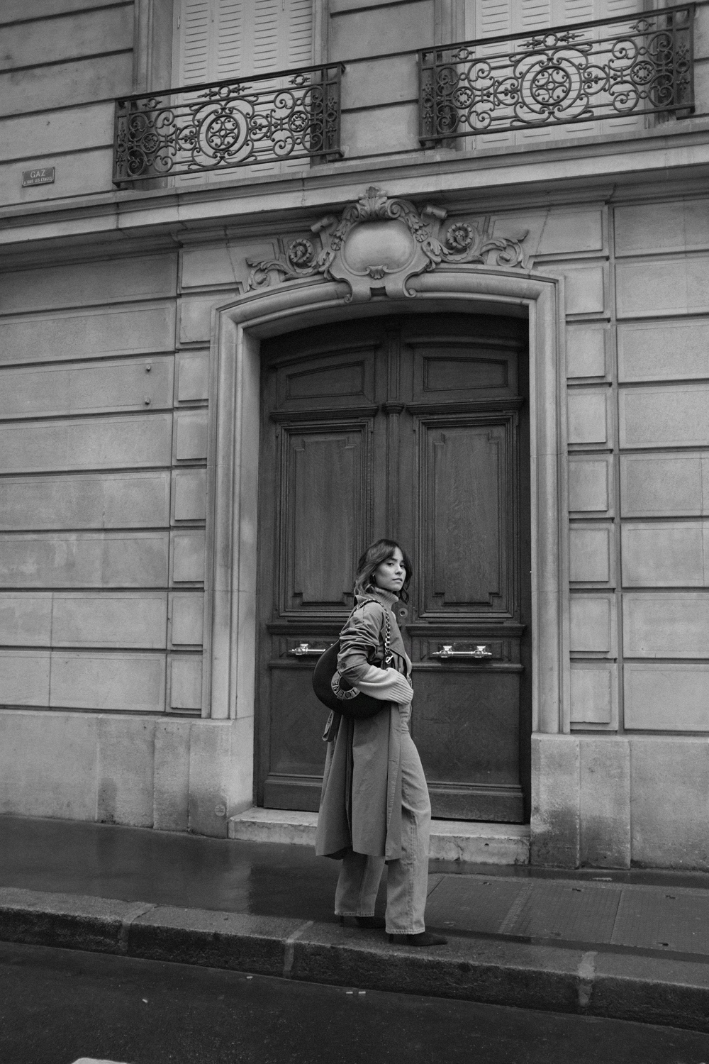 Nisi is wearing: Loewe Joyce bag, Céline Green Suede Boots, Trenchcoat, Turtleneck sweater, Wide denim jeans, L’Or Liquide Mini hoops
