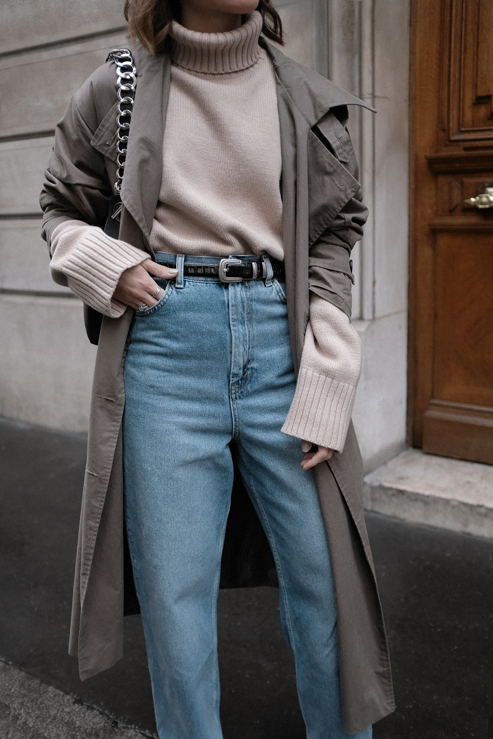 Nisi is wearing: Loewe Joyce bag, Céline Green Suede Boots, Trenchcoat, Turtleneck sweater, Wide denim jeans, L’Or Liquide Mini hoops