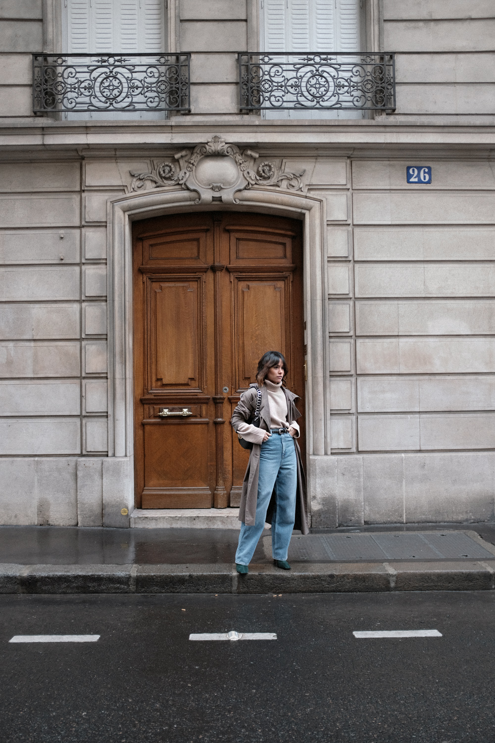 Nisi is wearing: Loewe Joyce bag, Céline Green Suede Boots, Trenchcoat, Turtleneck sweater, Wide denim jeans, L’Or Liquide Mini hoops