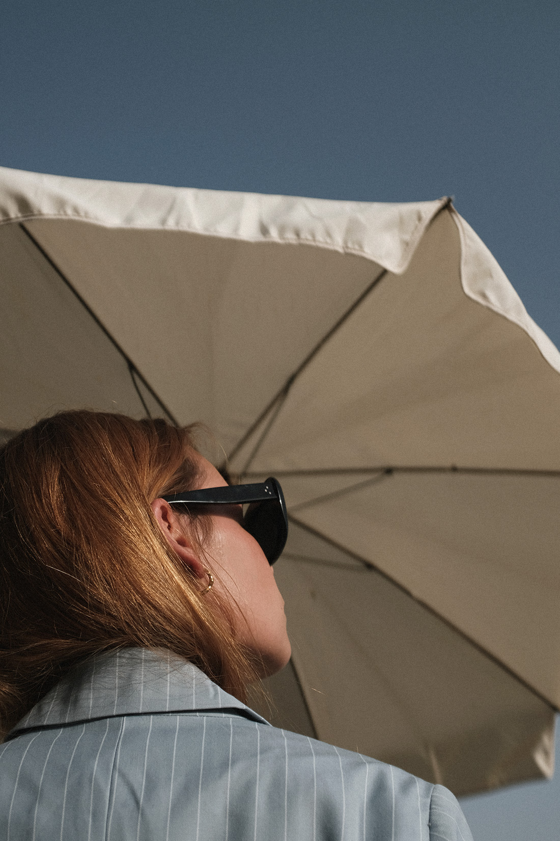 Desi is wearing: The Row Bow mules, Céline Sunglasses, Edited the Label Pinstripe blazer and pinstripe pencil skirt, Edited the Label silky white camisole