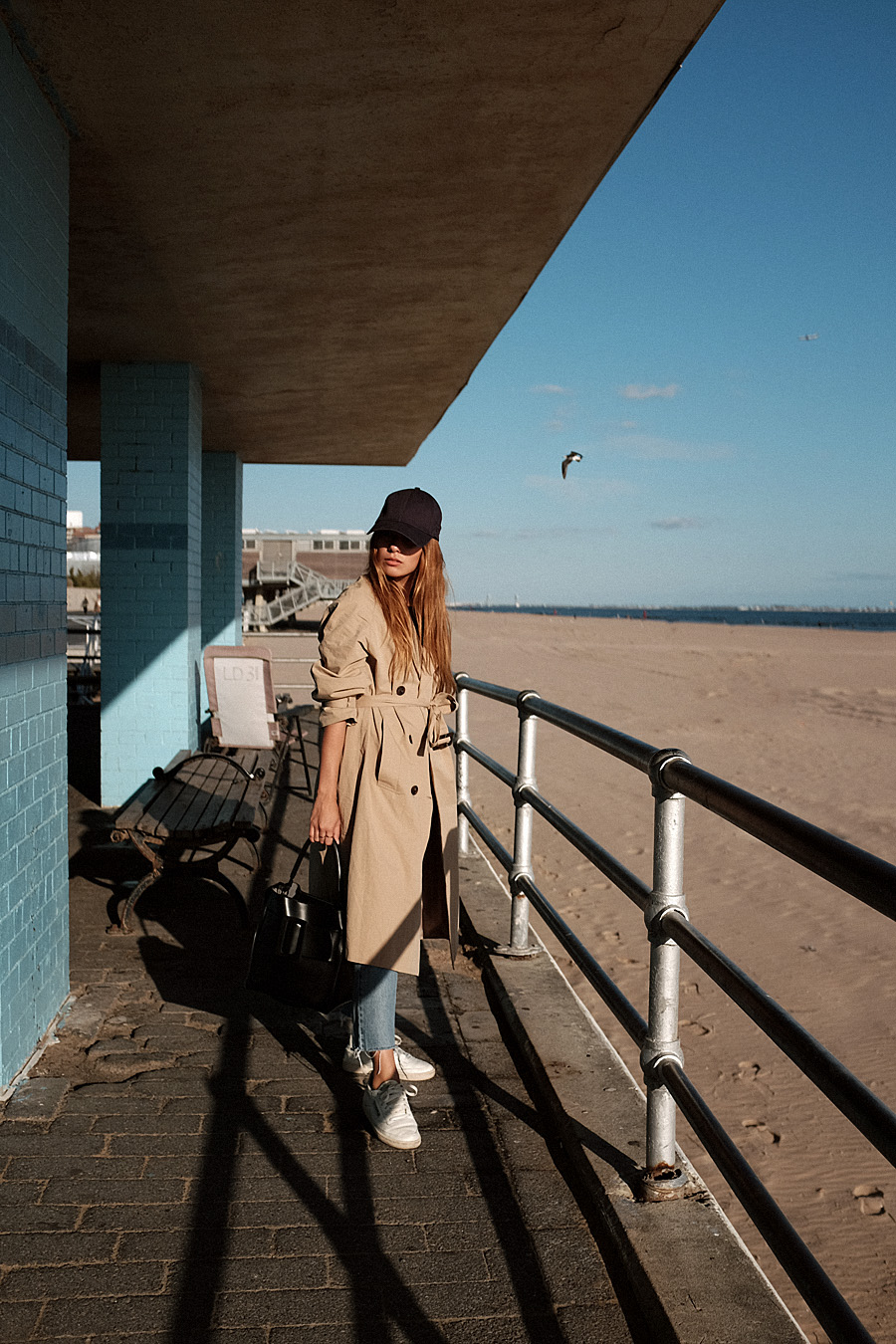 Outfit: Trenchcoat and Daddy Cap. Desi is wearing: Boyy Devon Bag, New Era Daddy cap, Trenchcoat – Moible, Mom jeans, Club C 85 Vintage Reebok Sneakers